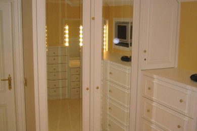 Foto de vestidor tradicional de tamaño medio con armarios con paneles con relieve, puertas de armario blancas y moqueta