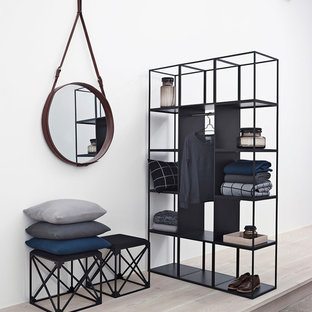 Ejemplo de armario y vestidor de hombre, escandinavo, de tamaño medio, con armarios abiertos, puertas de armario negras, suelo de madera clara y suelo beige