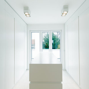 Foto de armario vestidor unisex, moderno, grande, con armarios con paneles lisos, puertas de armario blancas y suelo de baldosas de cerámica