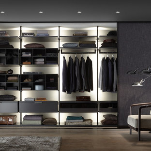 Imagen de vestidor de hombre, contemporáneo, de tamaño medio, con armarios abiertos, suelo de madera en tonos medios y suelo marrón