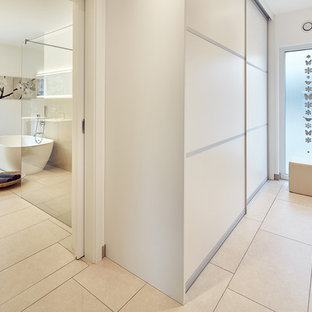 Foto de armario vestidor unisex, escandinavo, pequeño, con armarios con paneles lisos, puertas de armario blancas, suelo de baldosas de cerámica y suelo beige