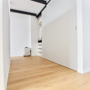 Esempio di un armadio o armadio a muro unisex minimalista di medie dimensioni con ante lisce, ante grigie, parquet chiaro e pavimento giallo