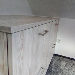 Ejemplo de armario y vestidor nórdico con armarios con paneles lisos, puertas de armario de madera clara, moqueta y suelo gris