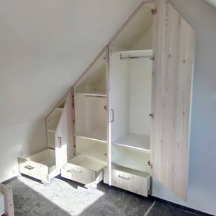 Modelo de armario y vestidor nórdico con armarios con paneles lisos, puertas de armario de madera clara, moqueta y suelo gris