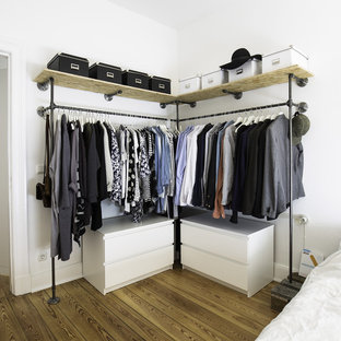 Esempio di una grande cabina armadio unisex industriale con nessun'anta, pavimento in legno massello medio, ante bianche e pavimento marrone