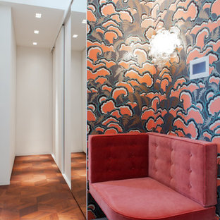 Inspiration för ett mellanstort eklektiskt walk-in-closet för könsneutrala, med släta luckor, vita skåp, mellanmörkt trägolv och brunt golv