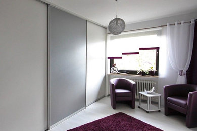Mittelgroßes Modernes Ankleidezimmer mit hellem Holzboden, weißem Boden, Ankleidebereich, flächenbündigen Schrankfronten und weißen Schränken in Sonstige