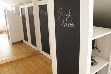 Kleines, Neutrales Modernes Ankleidezimmer mit flächenbündigen Schrankfronten, weißen Schränken und hellem Holzboden in Köln
