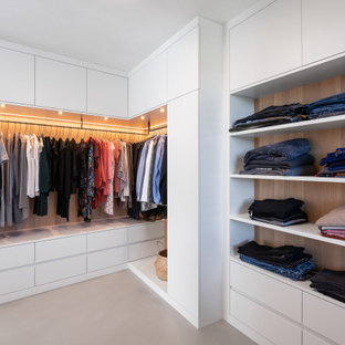 Neutraler, Großer Moderner Begehbarer Kleiderschrank mit Schrankfronten mit vertiefter Füllung, weißen Schränken, Betonboden und grauem Boden in München