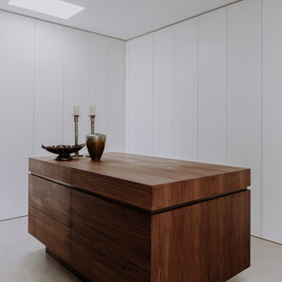 Imagen de vestidor unisex, moderno, grande, con armarios con paneles lisos, puertas de armario blancas, suelo de piedra caliza y suelo gris
