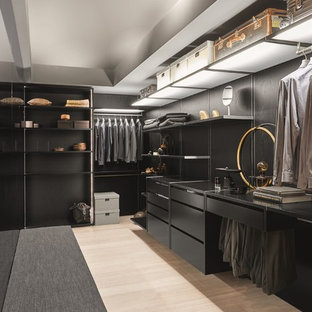Mittelgroßer Moderner Begehbarer Kleiderschrank mit schwarzen Schränken, hellem Holzboden und beigem Boden in Stuttgart