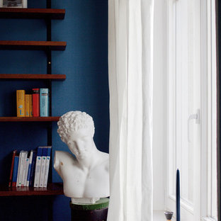 Aménagement d'un grand bureau rétro avec un mur bleu, un sol en bois brun, un poêle à bois, un manteau de cheminée en carrelage, un bureau indépendant et un sol marron.