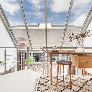 Kleines Modernes Arbeitszimmer ohne Kamin mit Arbeitsplatz, weißer Wandfarbe, Betonboden, freistehendem Schreibtisch und grauem Boden in Sonstige