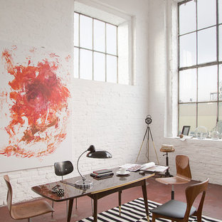 Mittelgroßes Industrial Arbeitszimmer ohne Kamin mit Arbeitsplatz, weißer Wandfarbe, Betonboden, freistehendem Schreibtisch und rotem Boden in Berlin