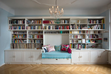 Modelo de despacho clásico extra grande con biblioteca, paredes blancas y suelo de madera en tonos medios