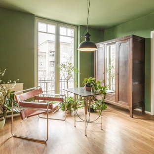 Mittelgroßes Eklektisches Arbeitszimmer ohne Kamin mit Arbeitsplatz, grüner Wandfarbe, braunem Holzboden, freistehendem Schreibtisch und braunem Boden in Hamburg