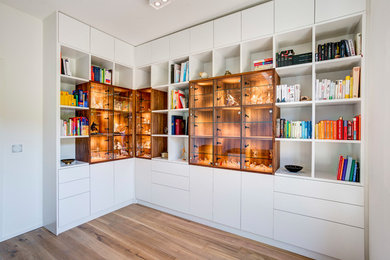 Kleines Modernes Lesezimmer ohne Kamin mit weißer Wandfarbe, braunem Holzboden und braunem Boden in Hamburg