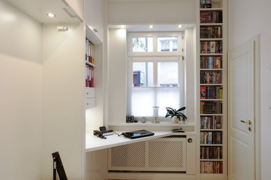 Mittelgroßes Modernes Arbeitszimmer mit Arbeitsplatz, weißer Wandfarbe, dunklem Holzboden, Einbau-Schreibtisch und braunem Boden in Sonstige