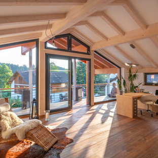 Klassisches Arbeitszimmer mit weißer Wandfarbe, braunem Holzboden, freistehendem Schreibtisch und braunem Boden in München