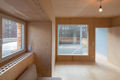 Mittelgroßes Modernes Arbeitszimmer mit Studio, brauner Wandfarbe, freistehendem Schreibtisch, Sperrholzboden, beigem Boden, Holzdecke und Holzwänden in Berlin