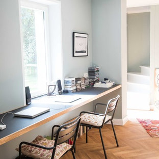 Mittelgroßes Klassisches Arbeitszimmer ohne Kamin mit Arbeitsplatz, grauer Wandfarbe, braunem Holzboden und Einbau-Schreibtisch in Berlin