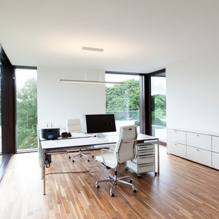 Exemple d'un grand bureau moderne avec un mur blanc, un sol en bois brun, un bureau indépendant et aucune cheminée.