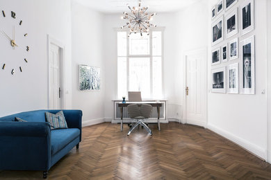 Ejemplo de despacho tradicional de tamaño medio con paredes blancas, suelo de madera en tonos medios, escritorio independiente y suelo marrón
