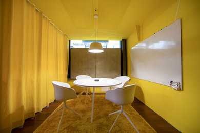 Modernes Arbeitszimmer mit Arbeitsplatz, gelber Wandfarbe, Teppichboden und gelbem Boden in Berlin