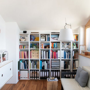 Mittelgroßes Nordisches Arbeitszimmer mit weißer Wandfarbe, braunem Holzboden, braunem Boden und Einbau-Schreibtisch in München