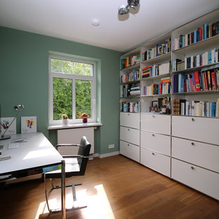Réalisation d'un bureau vintage de taille moyenne avec un mur vert, un sol en bois clair, un bureau indépendant, aucune cheminée et un sol marron.