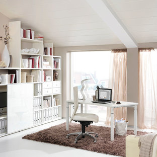 Mittelgroßes Skandinavisches Arbeitszimmer ohne Kamin mit Arbeitsplatz, beiger Wandfarbe, freistehendem Schreibtisch und weißem Boden in Dresden