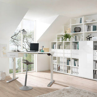 Mittelgroßes Modernes Arbeitszimmer ohne Kamin mit Arbeitsplatz, weißer Wandfarbe, hellem Holzboden, freistehendem Schreibtisch und beigem Boden in Dresden