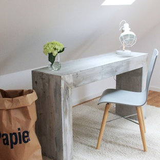 Kleines Nordisches Arbeitszimmer ohne Kamin mit Arbeitsplatz, weißer Wandfarbe, freistehendem Schreibtisch und hellem Holzboden in Köln