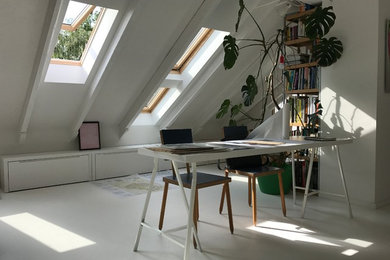 Diseño de estudio actual de tamaño medio con paredes blancas, suelo de cemento, todas las chimeneas, marco de chimenea de yeso, escritorio independiente y suelo blanco