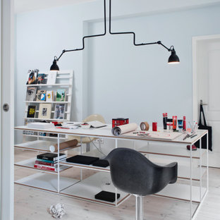 Skandinavisches Arbeitszimmer mit Arbeitsplatz, hellem Holzboden und weißem Boden in Berlin