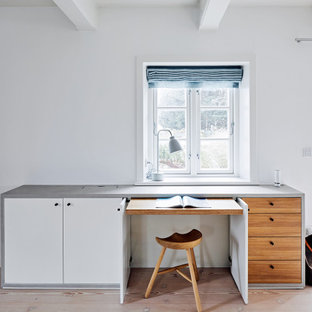 Modernes Arbeitszimmer mit weißer Wandfarbe, hellem Holzboden, Einbau-Schreibtisch, beigem Boden und freigelegten Dachbalken in Hamburg