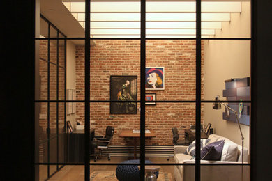 Home studio - large contemporary freestanding desk medium tone wood floor home studio idea in New York with beige walls