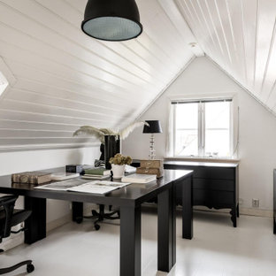Inredning av ett minimalistiskt arbetsrum, med vita väggar, målat trägolv, ett fristående skrivbord och vitt golv