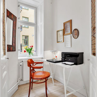 Idéer för ett minimalistiskt arbetsrum, med vita väggar, ljust trägolv, ett fristående skrivbord och beiget golv