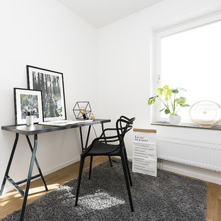 Inspiration för nordiska arbetsrum, med vita väggar, ljust trägolv, ett fristående skrivbord och brunt golv
