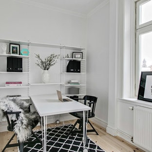Exempel på ett mellanstort skandinaviskt hemmabibliotek, med vita väggar, ljust trägolv, ett fristående skrivbord och beiget golv