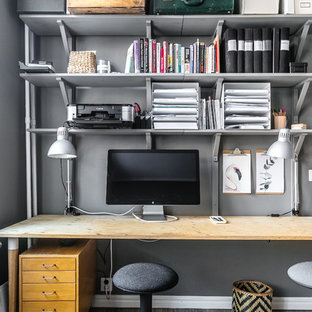 Inspiration för små minimalistiska hemmabibliotek, med grå väggar, mellanmörkt trägolv, ett fristående skrivbord och grått golv