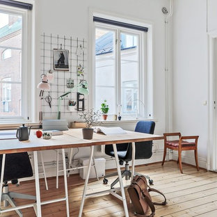 Idéer för minimalistiska hemmabibliotek, med vita väggar, ljust trägolv och ett fristående skrivbord