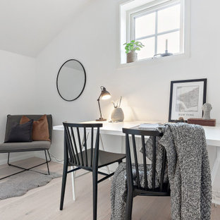 Idéer för att renovera ett mellanstort nordiskt hemmabibliotek, med vita väggar, ljust trägolv, ett fristående skrivbord och beiget golv