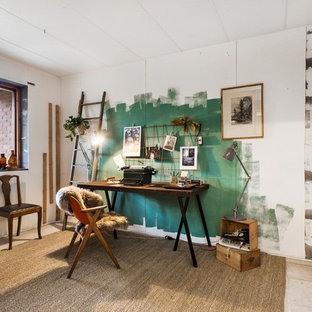 Mittelgroßes Industrial Arbeitszimmer ohne Kamin mit Studio, freistehendem Schreibtisch, Betonboden und weißer Wandfarbe in Stockholm