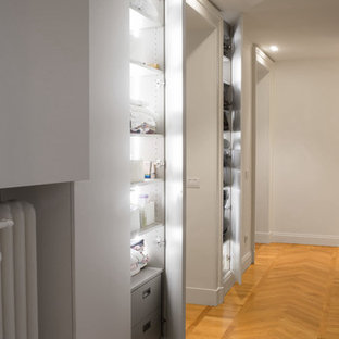 Idee per un piccolo armadio o armadio a muro unisex design con ante lisce, ante bianche e pavimento in legno massello medio