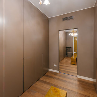 Idee per un grande spazio per vestirsi unisex contemporaneo con ante lisce, ante marroni e pavimento in legno massello medio