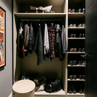 Imagen de armario vestidor unisex, ecléctico, extra grande, con armarios abiertos, puertas de armario grises, suelo de madera oscura y suelo gris