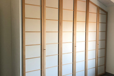 Foto di un grande armadio o armadio a muro unisex etnico con ante in legno chiaro
