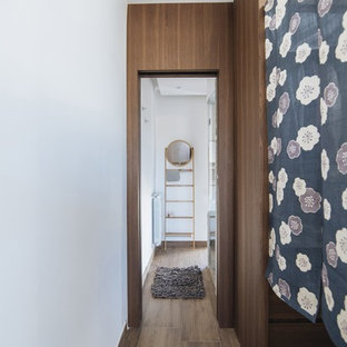 Modelo de armario vestidor unisex, mediterráneo, de tamaño medio, con armarios abiertos, puertas de armario de madera en tonos medios, suelo de madera en tonos medios y suelo marrón